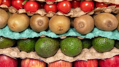 Verschiedene Schichten mit Obst und Gemüse, die mit einem papierbasierten Legenest getrennt sind.