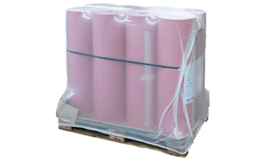 Auf einer Holzpalette stehen Produkte, die mit Schrumpffolie fixiert wurden.