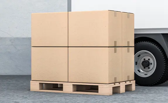 Vor einem LKW liegt eine Holzpalette mit 8 Modulkartons, die genau an die Palettengröße angepasst sind.