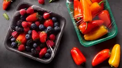Bild mit verpackten Obst & Gemüse vergrößern Auf einem Tisch liegen 2 Kunststoffverpackungen mit Non-PVC-Lebensmittelfolie, in denen Obst und Gemüse verpackt ist.