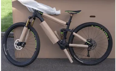 Fahrradrahmen, Fahrradgabel und Pedale eines Fahrrad wird mit selbstklebenden Wellpappe für den Transport geschützt.