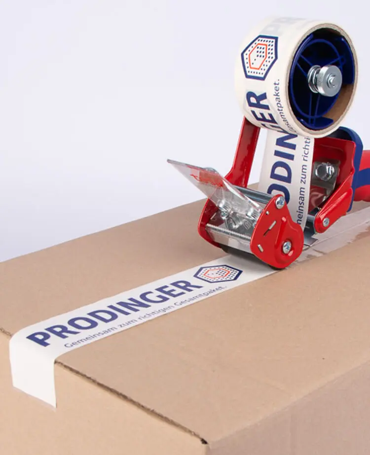 Ein Karton wird mit einem personalisierten Paketband verschlossen.