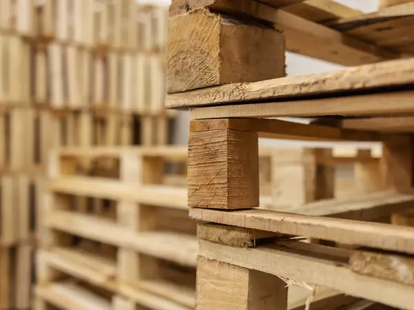 In einem Lager stapeln sich Transport-Paletten.