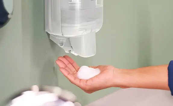 Mit einem Seifenschaumspender wurde Schaum auf eine Hand geschäumt.