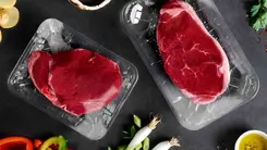 Bild mit verpackten Steaks vergrößern Auf einem Tisch liegen 2 mit Non-PVC-Lebensmittelfolie verpackte Steaks.