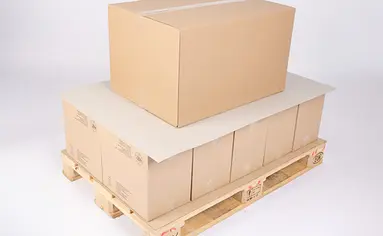 Auf einer Holzpalette stapeln Kartons, die mit Zuschnitten unterteilt wurden.
