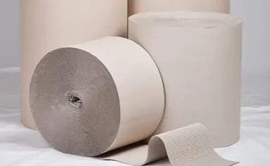 Mehrere Rollen mit Wellpappe liegen und stehen beieinander.